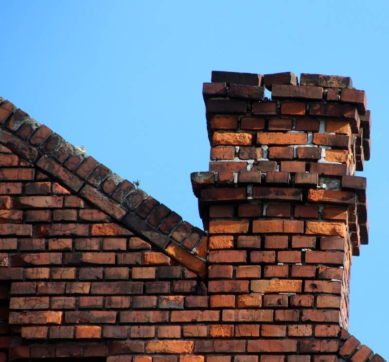 Damaged chimney on an Media home showing cracks and missing mortar